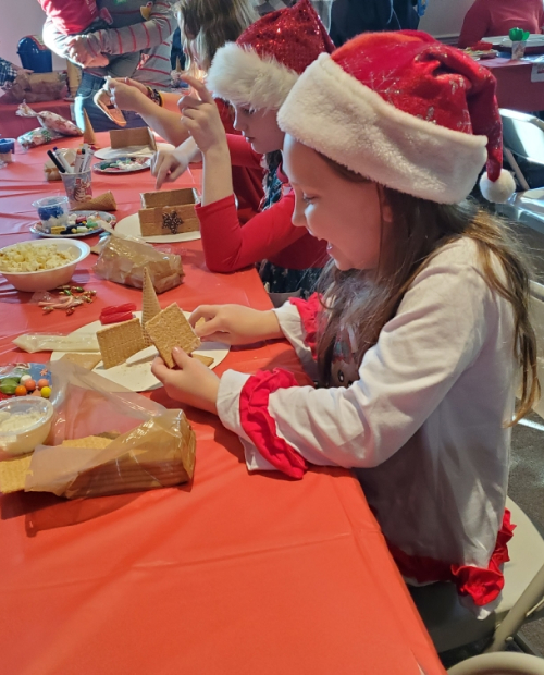 Girl building gingerbread house