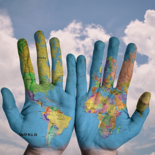 Hands with world map painted on them