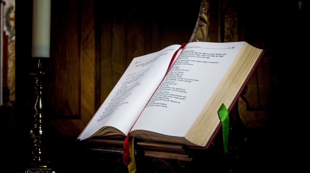 A bible with a candle next to it